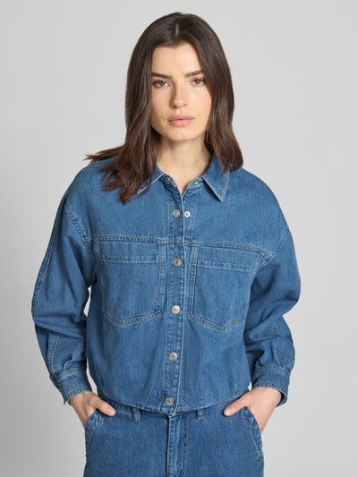 Kobiece modelka nosi kurtka jeansowa z kieszeniami na piersi model 'Imke' od JOOP!, bawełna, krój relaxed fit, kołnierzyk koszulowy, listwa guzikowa, długość tyłu w rozmiarze 36: 54 cm, szerokość ramion w rozmiarze 36: 54 cm, szerokość klatki piersiowej w rozmiarze 36: 60 cm, długość rękawów w rozmiarze 36: 52 cm, wygląd frontowy, całkowite ujęcie.