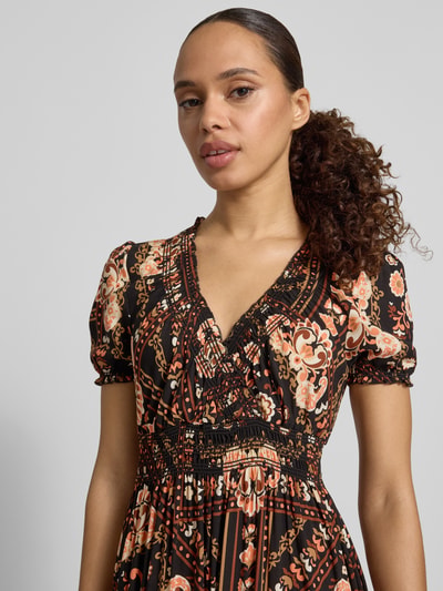 Frauenmodel trägt Maxikleid aus Viskose mit V-Ausschnitt von Apricot, Taillierter Schnitt, Smok-Detail, Rüschenärmel, Volantsaum, Nahaufnahme Oberkörper.