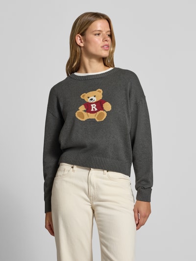 Frauenmodel trägt Strickpullover aus reiner Baumwolle von REVIEW in Dunkelgrau mit Bärchen-Motiv, lockere Passform, Nahaufnahme Oberkörper.
