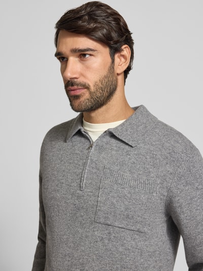 Mannenmodel draagt grijze gebreide pullover uit wolmix met polokraag, ritssluiting en borstzak Model 'FELIPO' van Casual Friday, slim fit, ruglengte bij maat M 67 cm, detailopname bovenlichaam.