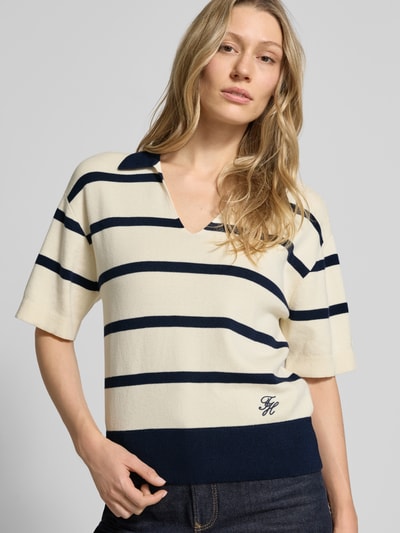 Kobiece modelka nosi Regular Fit Pullover aus reiner Baumwolle von Tommy Hilfiger, efekt: wzór w paski, krótki rękaw, kołnierzyk polo, wyhaftowane logo, drobny splot, sweter z bawełny, widok na górną część ciała z przodu.