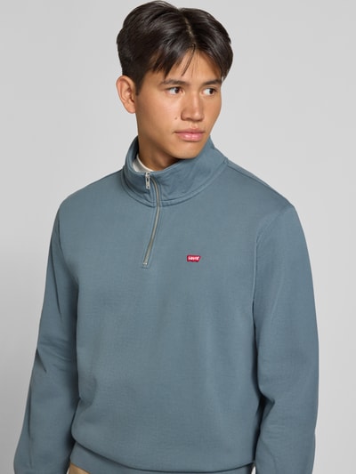 Männermodel trägt Regular Fit Pullover aus reiner Baumwolle von Levi's® in Blauton, glatte Struktur, Nahaufnahme Oberkörper.