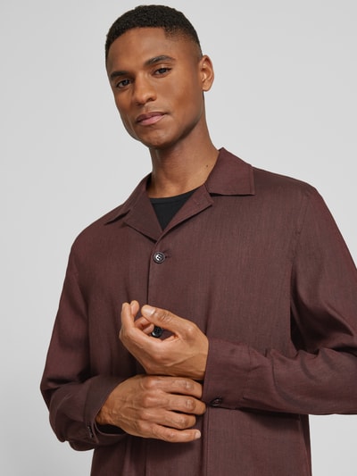 Männermodel trägt Regular Fit Hemdjacke aus Leinen-Mix Modell 'Malte' von CINQUE, Reverskragen, Knopfleiste, Nahaufnahme Oberkörper. Herren Hemdjacke mit Viskose-Anteil, Rückenlänge 74 cm bei Größe M, feine Struktur, warme braune Farbe.