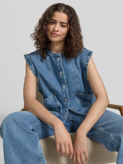 Kobiece model prezentuje Jeansweste mit Eingrifftaschen von Jake*s Casual, niebieski denim, krój regular fit, okrągły dekolt, listwa guzikowa, wpuszczane kieszenie, falisty brzeg, długość tyłu w rozmiarze 36: 56 cm, szerokość w rozmiarze 36: 48 cm, zdjęcie w zbliżeniu na górną część ciała