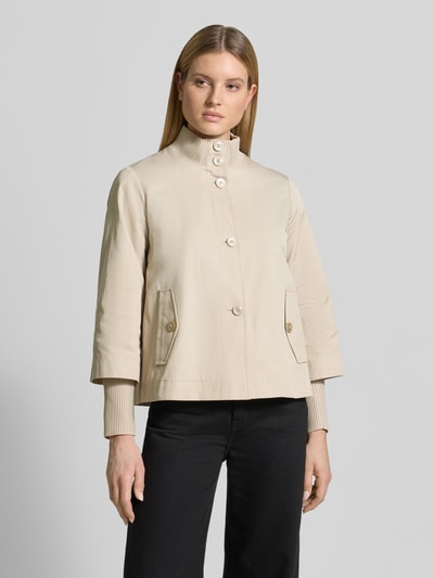 Frauenmodel trägt Regular Fit Jacke aus Baumwoll-Mix von s.Oliver BLACK LABEL, efekt: jednolity kolor, krój regular fit, stójka, zapięcie: listwa guzikowa, aplikacja z logo z metalu, pas na plecach z kontrafałdą, rękaw: długi rękaw, zakończenie rękawów: prążkowane, długie dodatkowe ściągacze na rękawach, kieszenie z patką, mieszanka bawełny. Ganzkörperansicht von vorne.