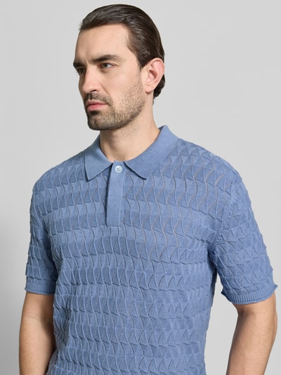 Männermodel trägt Regular Fit Poloshirt mit Strukturmuster von Scotch & Soda in hellblau aus reiner Baumwolle, Nahaufnahme Oberkörper.