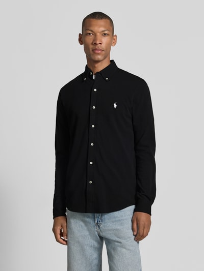 Männermodel trägt Regular Fit Freizeithemd aus reiner Baumwolle von Polo Ralph Lauren in Schwarz mit weißen Knöpfen, Ganzkörperansicht von vorne. Herren Freizeithemd von Polo Ralph Lauren.