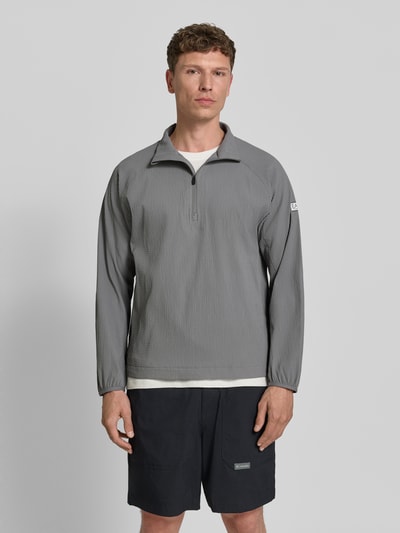 Männermodel trägt Regular Fit Sweatshirt mit Strukturmuster von EA7 Emporio Armani in Grau, elastischer Material-Mix, Logo-Patch, Ganzkörperansicht von vorne