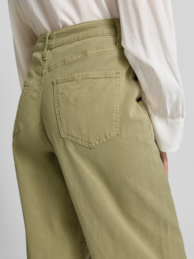 Frauenmodel trägt Barrel Fit Jeans aus Baumwoll-Mix von s.Oliver RED LABEL in hellem Olivgrün mit Gesäßtasche, Nahaufnahme Rückansicht.