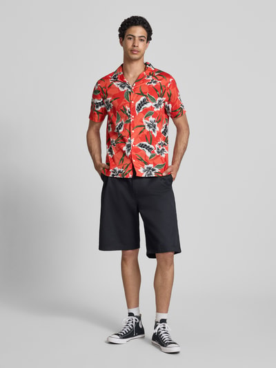 Männermodel trägt Regular Fit Freizeithemd mit Reverskragen von Superdry in Rot mit floralen Mustern, reine Baumwolle, Ganzkörperansicht von vorne.