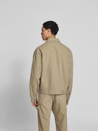Männermodel trägt Jeansjacke aus Reiner Baumwolle von Forét in Beige, Regular-Fit, Umlegekragen, Rückansicht, Ganzkörperansicht.