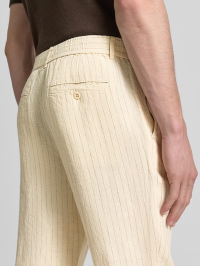 Männermodel trägt Straight Fit Leinenhose mit Gesäßtaschen von Gant in Beige mit feiner Struktur, Reine Leinen, Detailaufnahme Rückansicht.
