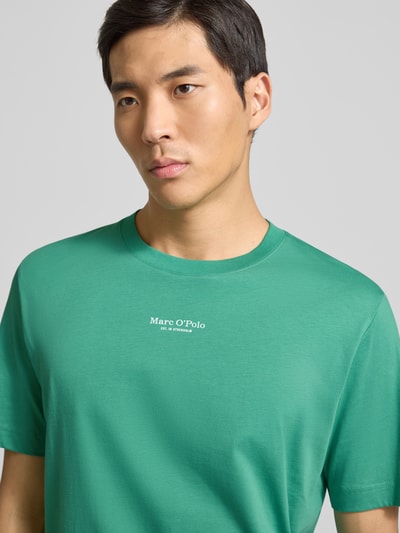 Männermodel trägt Regular Fit T-Shirt aus reiner Baumwolle von Marc O'Polo in Optik: Unifarben mit Label-Print, Rundhals, Kurzarm, Jersey; Nahaufnahme Oberkörper.