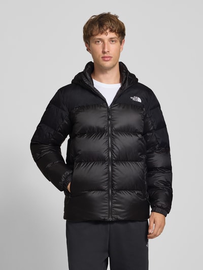 Männermodel trägt Regular Fit Jacke in Stepp-Optik Modell 'Diabolo' von The North Face in Schwarz mit Stehkragen und Logo-Stitching, Ganzkörperansicht von vorne.