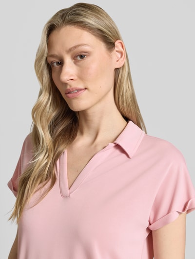 Frauenmodel trägt Regular Fit Poloshirt aus Modal-Mix von Christian Berg Woman in Rosa mit V-Ausschnitt und Aufschlag an den Ärmeln, Nahaufnahme Oberkörper. Rückenlänge bei Größe S: 46 cm.