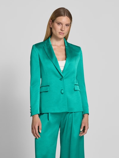 Kobiece modelka nosi Slim Fit Blazer mit Reverskragen und Pattentaschen von Marc Cain z satyny, krój slim fit, kieszenie z patką, zapięcie na guzik, długość tyłu w rozmiarze 36: 65 cm, szerokość w rozmiarze 36: 45 cm, długość rękawów w rozmiarze 36: 61 cm, zielony, gładka tekstura, prostokątne formy, Nahaufnahme Oberkörper.