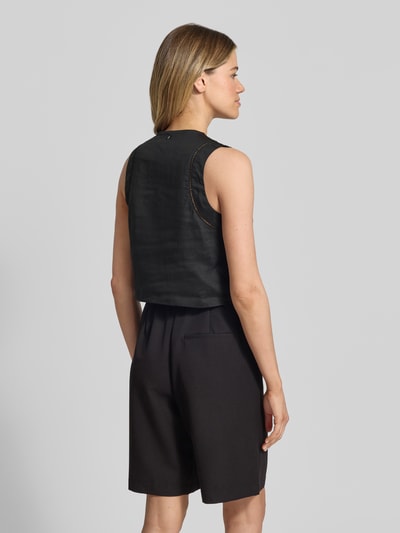 Frauenmodel trägt Besticktes Top aus Baumwoll-Mix mit Bindedetails Modell 'IRIKA' von BOSS Orange in Schwarz, Struktur leicht glänzend, unifarben, Regular Fit, Materialtextur glatt, Detailstickerei sichtbar, Ganzkörperansicht Rückansicht.