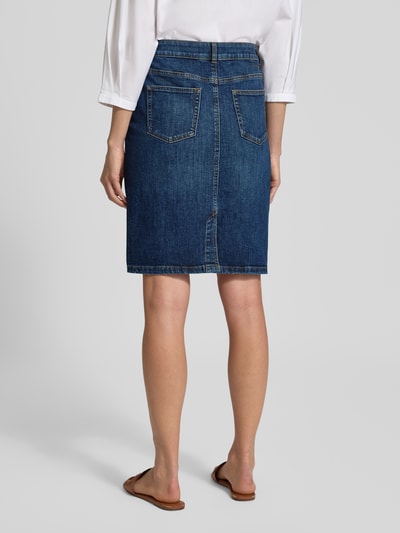 Männermodel trägt Regular Fit Rock in Denim-Optik von Christian Berg Woman, mieszanka bawełny, krój regular fit, długość do kolan, 5 kieszeni, zapięcie na guzik i zamek błyskawiczny, szerokość w rozmiarze 36: 39 cm, całkowita długość w rozmiarze 36: 57 cm, kolor niebieski o wyraźnej, teksturowanej strukturze, imitacja denimu, widoczne przeszycia, widok całej sylwetki z tyłu.