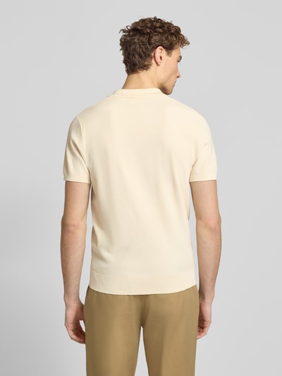 Männermodel trägt Regular Fit Poloshirt aus Lyocell-Mix mit Seiden-Anteil von Profuomo in Beige mit Strukturmuster, Ganzkörperansicht Rückansicht.