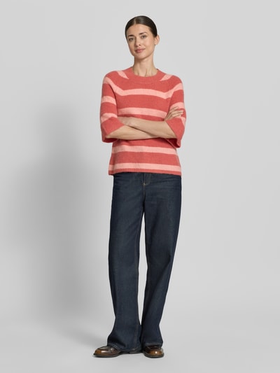 Frauenmodel trägt Strickpullover mit 1/2-Arm Modell 'Milania Hope' von MSCH Copenhagen, Material-Mix mit Alpaka-Anteil, Gerader-Schnitt, Rundhalsausschnitt, Rückenlänge 52 cm, Ärmellänge 36 cm, rosa-gestreift, weiche Textur, Ganzkörperansicht von vorne.