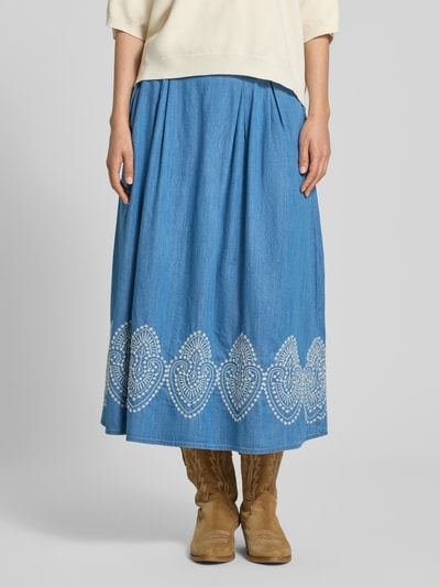 Frauenmodel trägt Midirock in Denim-Optik mit Stitchings von More & More, Baumwoll-Lyocell-Mix, A-Linie, hellblau mit weißen Mustern, Ganzkörperansicht von vorne.