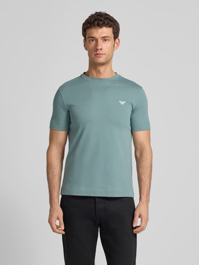 Männermodel trägt T-Shirt mit Label-Stitching und Rundhalsausschnitt von Emporio Armani in Hellblau, Slim Fit, Oberkörperansicht von vorne.