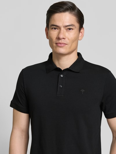 Männermodel trägt Regular Fit Poloshirt mit Knopfleiste Modell 'Carlosjuan' von JOOP! Collection in Schwarz, Nahaufnahme Oberkörper.