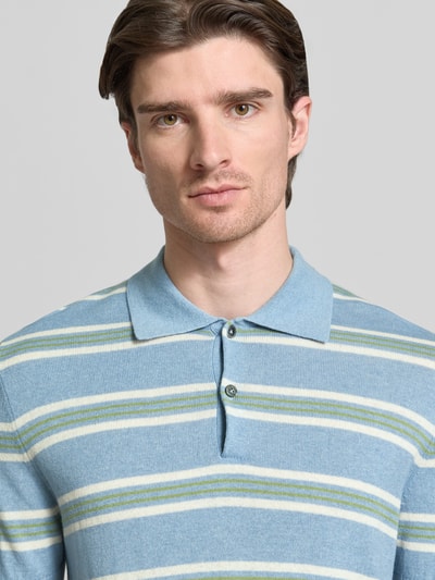 Männermodel trägt Poloshirt aus Baumwoll-Lyocell-Mix mit Kaschmir-Anteil mit gerippten Abschlüssen von FTC-Cashmere, blau-grün gestreift, Nahaufnahme Oberkörper. Regular Fit, Polokragen, kurze Knopfleiste.