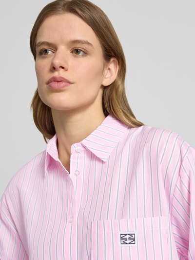 Mädchen trägt bluzka koszulowa z mieszanki bawełny, krój loose fit, kołnierzyk koszulowy, listwa guzikowa, brustasza, naszywka z logo, model 'FRIDA' od Noisy May, pastelowe paski, długość tyłu 76 cm, długość rękawów 53 cm, widok z przodu, zbliżenie na górną część.