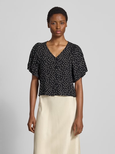 Vrouwenmodel draagt blouse met korte mouwen van zuiver viscose, Slim fit, Model 'GILDA' van Soyaconcept, V-hals, pofmouwen, knoopsluiting, zwarte stof met witte stippen, Ganzkörperaanzicht van voren.