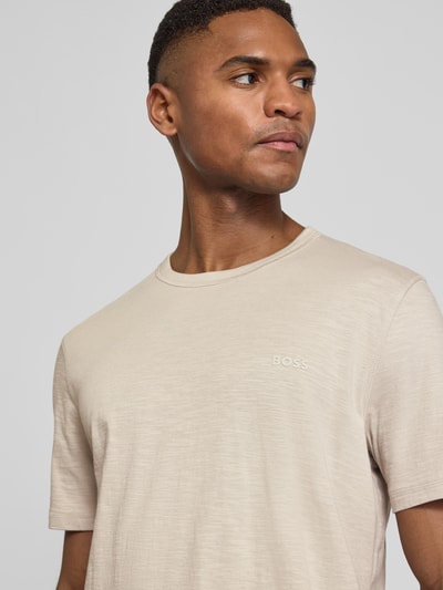 Männermodel trägt Regular Fit T-Shirt aus strukturierter Baumwolle Modell 'TEGOOD' von BOSS Orange in Beige mit Rundhals, Nahaufnahme Oberkörper.