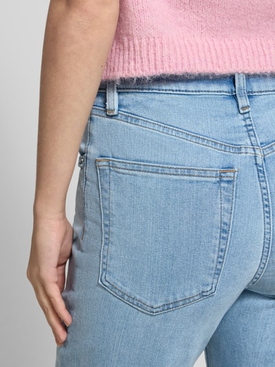 Kobieta nosi Sli Fit Jeans mit 5-Pocket-Design von Calvin Klein Jeans, bawełniany mix ze stretchem, jasnoniebieski kolor, detal z logo, detailaufnahme pleców.