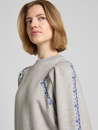 Modelka nosi bluzę Sweatshirt mit Stitchings Modell 'MESTA' od Bash z mieszanki bawełny z dodatkiem streczu, krój regular fit, hafty, okrągły dekolt. Zbliżenie na górną część ciała, widok z przodu.