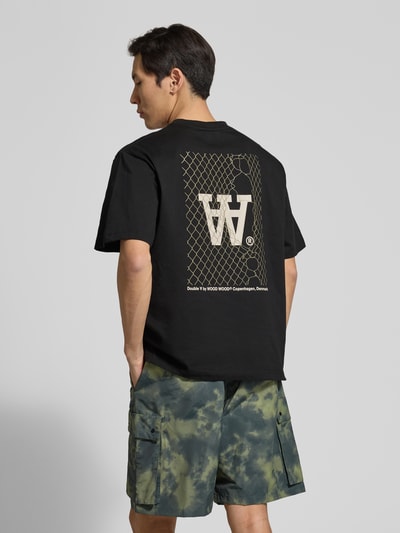 Männermodel trägt T-Shirt mit Rundhalsausschnitt Modell 'Liam' von Wood Wood aus reiner Baumwolle, krój regular fit, label-print, tył, Ganzkörperansicht Rückansicht