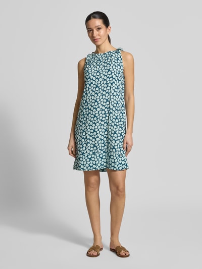 Frauenmodel trägt Relaxed Fit Midikleid aus reiner Viskose von ZABAIONE, blau mit weißem Muster, U-Boot-Ausschnitt, Falten-Optik, Ärmelloses-Design, Rückenlänge 82 cm, Brustweite 50 cm, Ganzkörperansicht von vorne.