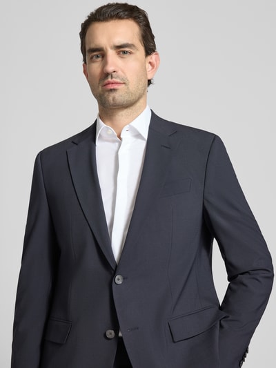 Männermodel trägt Regular Fit Anzugsakko aus Schurwoll-Mix Modell 'H-Jasper-MM-C-NF' von BOSS in Dunkelblau, Nahaufnahme Oberkörper.