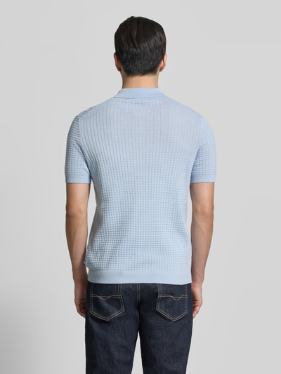 Männermodel trägt Slim Fit Poloshirt in Strick-Optik Modell 'Vanceo' von JOOP! Collection, reine Baumwolle, hellblau, Ganzkörperansicht Rückansicht.