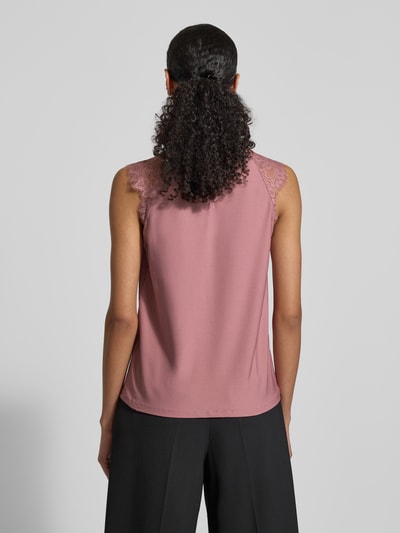 Vrouwenmodel draagt Regular fit blusentop met kant model 'MILLA' van Vero Moda, roze, unilook, staande kraag, keyhole rug, detailopname rugaanzicht.
