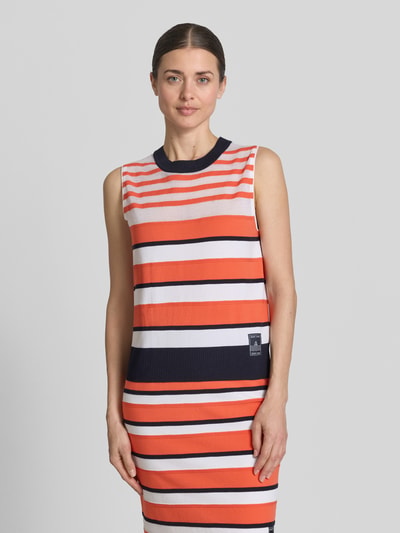Frauenmodel trägt Pullunder aus Lyocell-Mix im Allover-Look von Marc Cain in Orange, Weiß, Rot mit Label-Detail, Rundhalsausschnitt, Regular-Fit, Rückenlänge bei Größe 36 52 cm, Nahaufnahme Oberkörper.