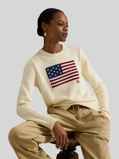 Frauenmodel trägt Strickpullover mit Flaggen-Motiv und Rundhalsausschnitt von Polo Ralph Lauren, cremefarben, Baumwolle, Ganzkörperansicht von vorne.
