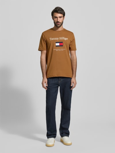 Männermodel trägt Regular Fit T-Shirt aus reiner Baumwolle von Tommy Hilfiger, Optik: unifarben, Label-Schriftzug, Jersey, Rundhals, Kurzarm, Ganzkörperansicht von vorne.
