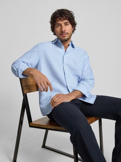 Männermodel trägt Regular Fit Freizeithemd aus Leinen-Baumwoll-Mix Modell 'CLAY LINENBLEND' von SELECTED HOMME in hellem Blau, Melange-Optik, Kentkragen, durchgehende Knopfleiste, Flammgarn-Textur, Ganzkörperansicht von vorne.