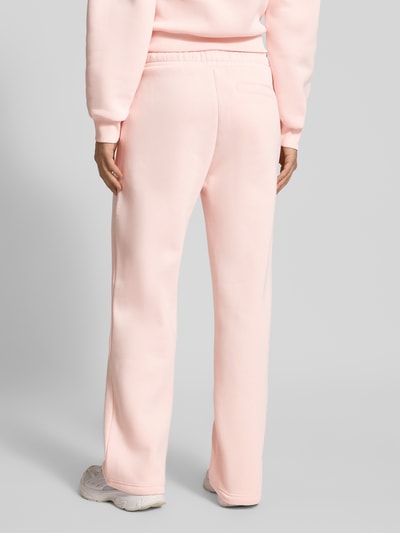 Frauenmodel trägt Straight Leg Sweatpants mit Logo und elastischem Bund von Review, rosa, Baumwoll-Mix, Ganzkörperansicht Rückansicht.