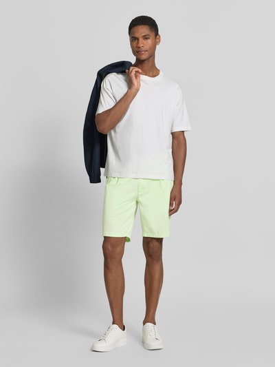 Männermodel trägt Relaxed Fit Bermuda aus Baumwoll-Mix Modell 'TINO' von Brax, Optik: Unifarben, Ganzkörperansicht von vorne.