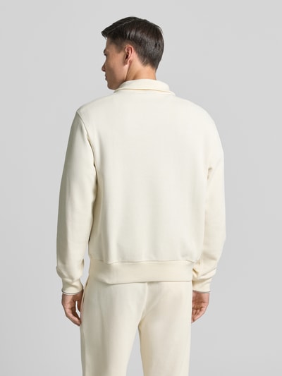 Männermodel trägt Regular Fit Troyer aus reiner Baumwolle Modell 'C-SEIDLER 55' von BOSS in Optik: unifarben, Stricktextur, Rumpfabschluss: gerippt, Ärmelabschluss: gerippt, Materialverarbeitung: Strick, Farbe hell, Ganzkörperansicht Rückansicht.