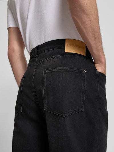 Männermodel trägt Baggy Fit Jeans im Five-Pocket-Design von REVIEW, schwarze Waschung, Baumwoll-Elasthan-Mix, Nahaufnahme Rückansicht.