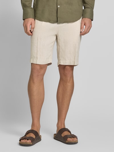 Mężczyzna nosi Shorts aus Leinen mit Eingrifftaschen von MARKUP, beżowy len, krój straight fit, widok całej sylwetki z przodu, Szerokość w rozmiarze 50: 22 cm, długość nogawki wewnętrznej: 34 cm, kieszenie francuskie z przodu, kieszenie z lamówką i zapięciem na guzik z tyłu.