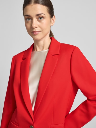 Frauenmodel trägt Regular Fit Blazer mit Reverskragen von comma in Rot mit Paspeltaschen, Knopfverschluss, Nahaufnahme Oberkörper.
