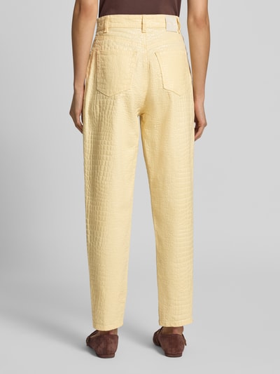 Frauenmodel trägt Relaxed Fit Hose im Allover-Look von Marc Cain aus Baumwoll-Elasthan-Mix in Hellgelb mit strukturierter Oberfläche, Ganzkörperansicht Rückansicht.