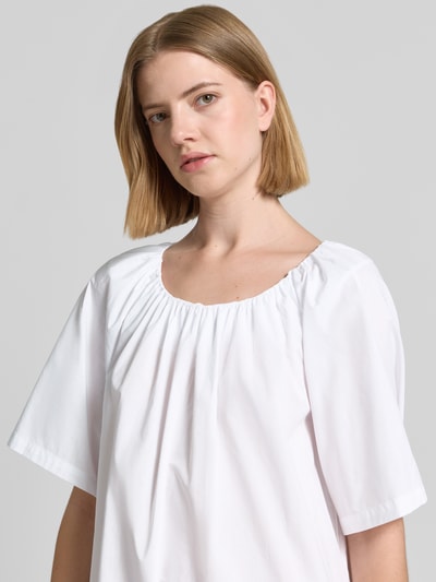 Frauenmodel trägt Knielanges Kleid mit Lochstickerei und Rundhalsausschnitt von Christian Berg Woman aus Reine Baumwolle, Nahaufnahme Oberkörper.